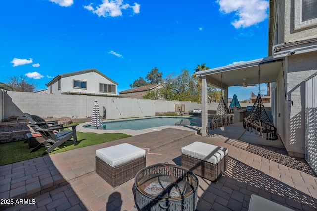 view of pool featuring ceiling fan, an outdoor fire pit, a fenced backyard, a fenced in pool, and a patio area