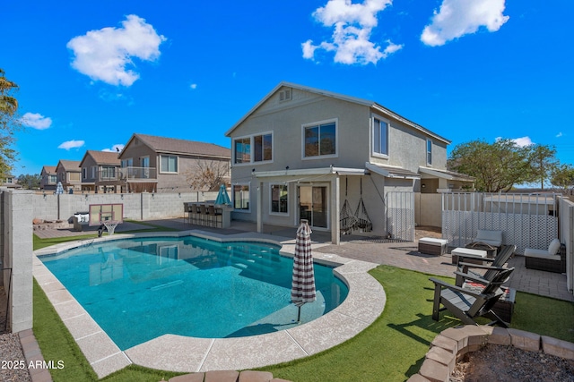 rear view of house featuring stucco siding, a fenced backyard, a fenced in pool, and a patio