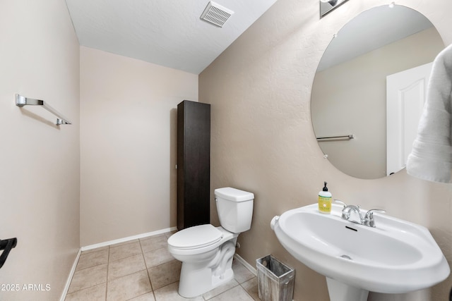 bathroom with visible vents, toilet, a sink, tile patterned flooring, and baseboards