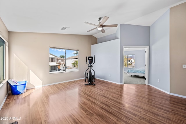 workout area with lofted ceiling, wood finished floors, a ceiling fan, visible vents, and baseboards