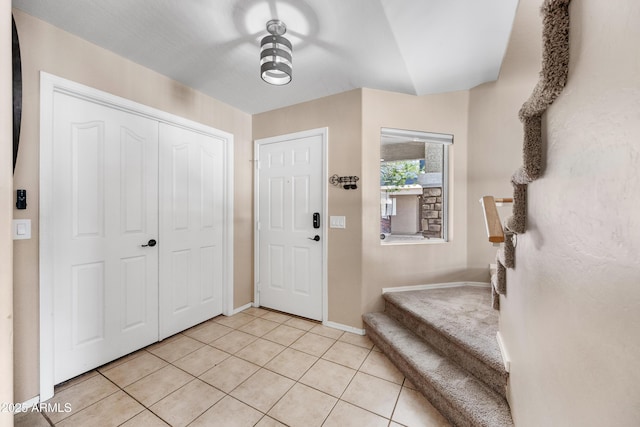 entrance foyer with light tile patterned floors and baseboards