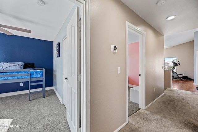 hall featuring carpet and baseboards