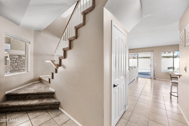 stairway featuring baseboards and tile patterned floors