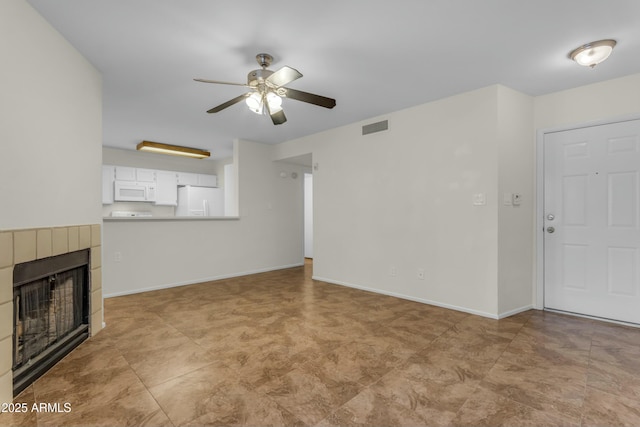 unfurnished living room featuring a tiled fireplace and ceiling fan