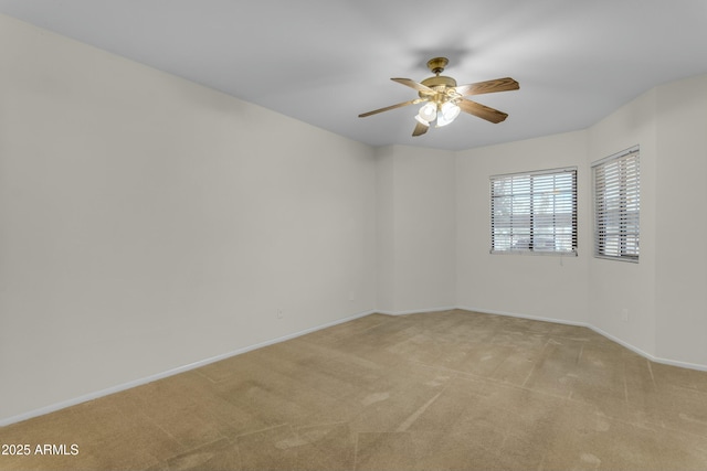 spare room featuring light carpet and ceiling fan