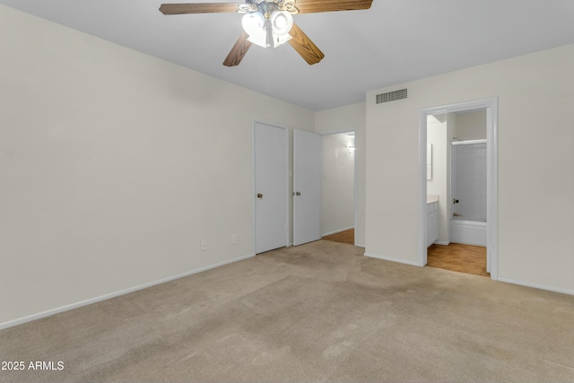 unfurnished bedroom with connected bathroom and light carpet