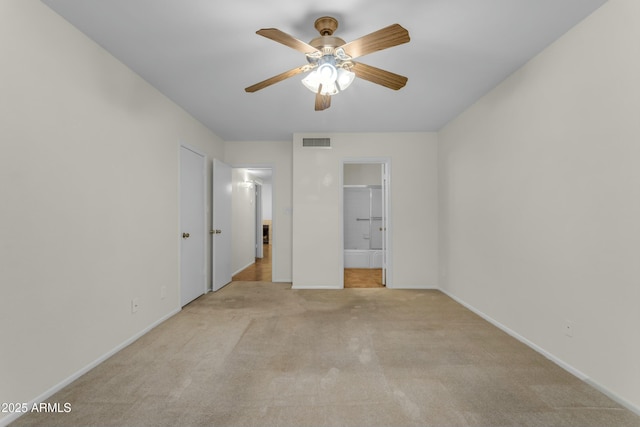 unfurnished bedroom with ensuite bath, light colored carpet, and ceiling fan