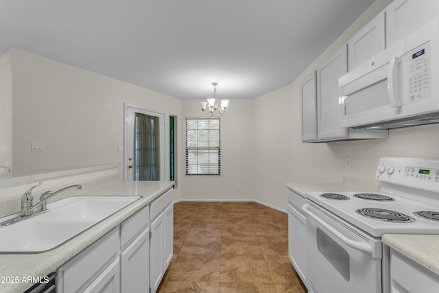 kitchen featuring pendant lighting, white appliances, white cabinetry, and sink