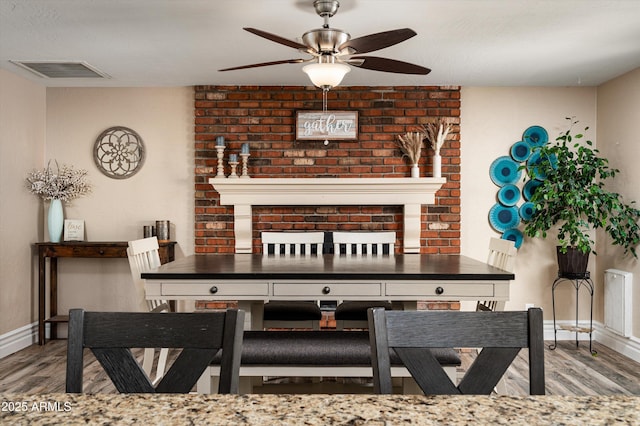 living room featuring hardwood / wood-style flooring, a fireplace, and ceiling fan