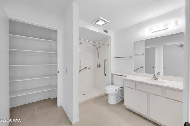 bathroom featuring a spacious closet, tile patterned flooring, a shower stall, and visible vents