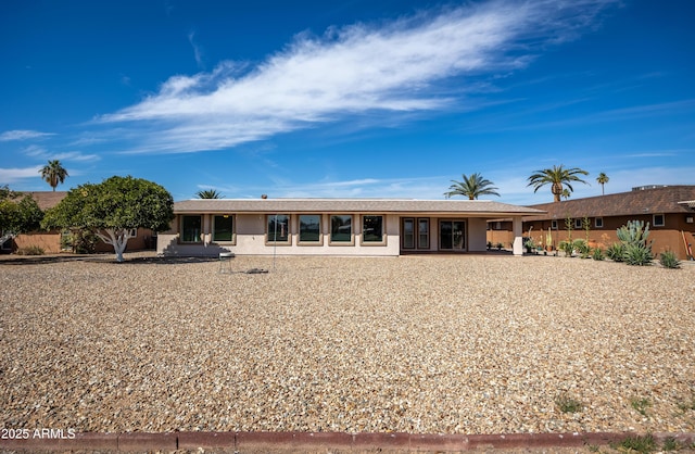 rear view of property featuring stucco siding
