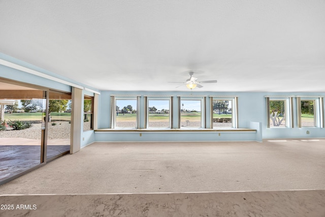 interior space with light carpet and ceiling fan
