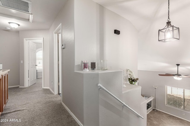 hall with a wealth of natural light, light colored carpet, and lofted ceiling