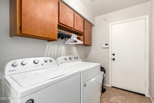 washroom with cabinets, light tile patterned floors, and washing machine and clothes dryer