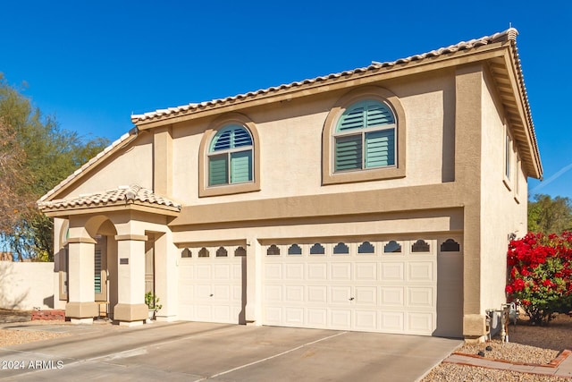 mediterranean / spanish home with a garage