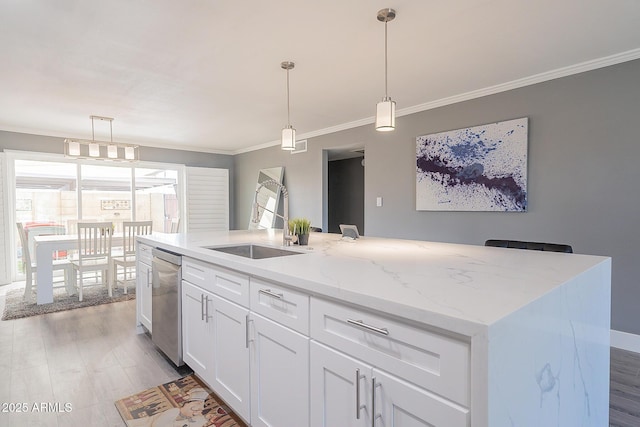 kitchen featuring pendant lighting, stainless steel dishwasher, a kitchen island with sink, and white cabinets