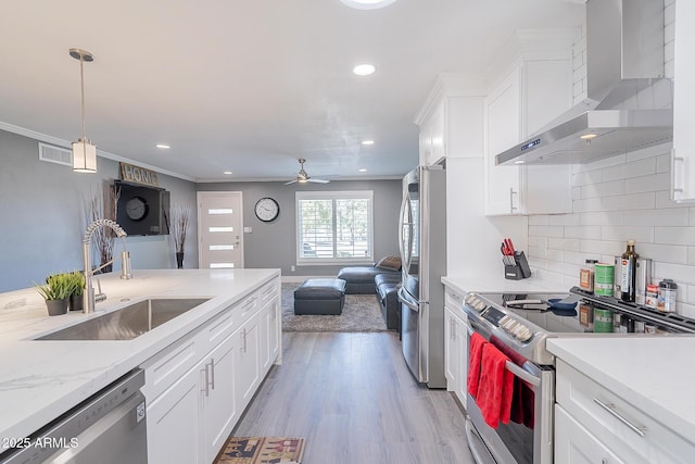 kitchen with white cabinetry, wall chimney range hood, sink, and appliances with stainless steel finishes