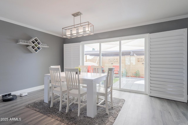 dining area with crown molding and hardwood / wood-style flooring