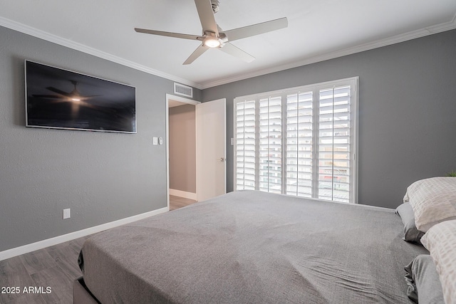 bedroom featuring wood-type flooring, ornamental molding, and ceiling fan