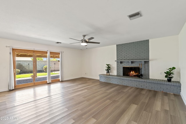 unfurnished living room featuring visible vents, baseboards, ceiling fan, and wood finished floors