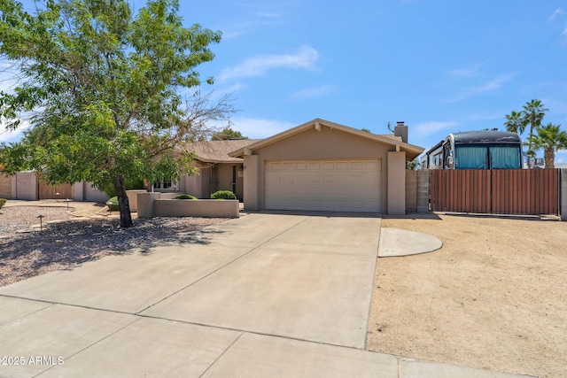 ranch-style home with fence, an attached garage, stucco siding, a chimney, and driveway