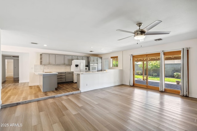 unfurnished living room featuring recessed lighting, a ceiling fan, baseboards, light wood-type flooring, and visible vents
