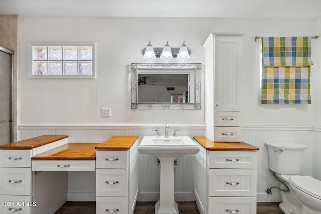 bathroom featuring wainscoting and toilet