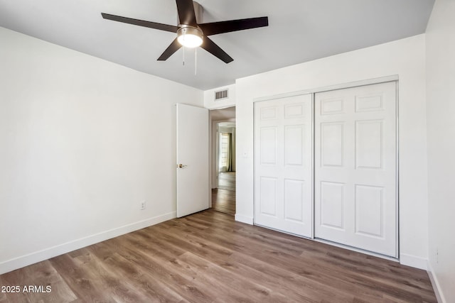 unfurnished bedroom featuring visible vents, baseboards, and wood finished floors