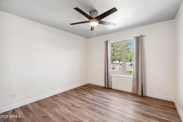 empty room with baseboards, ceiling fan, and light wood-style flooring
