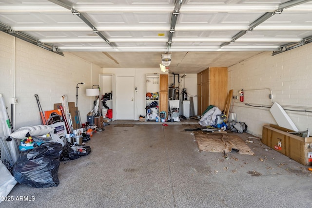 garage with a garage door opener and concrete block wall