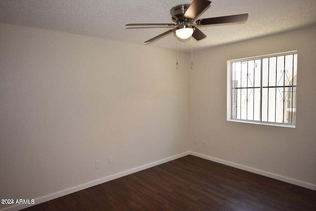 spare room featuring ceiling fan, dark wood-type flooring, and a textured ceiling