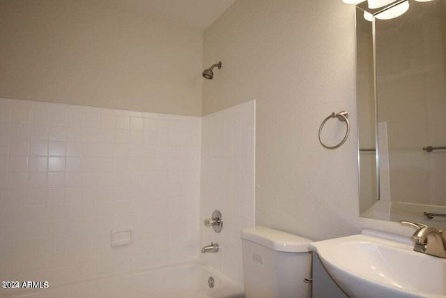 full bathroom featuring tiled shower / bath combo, toilet, and vanity