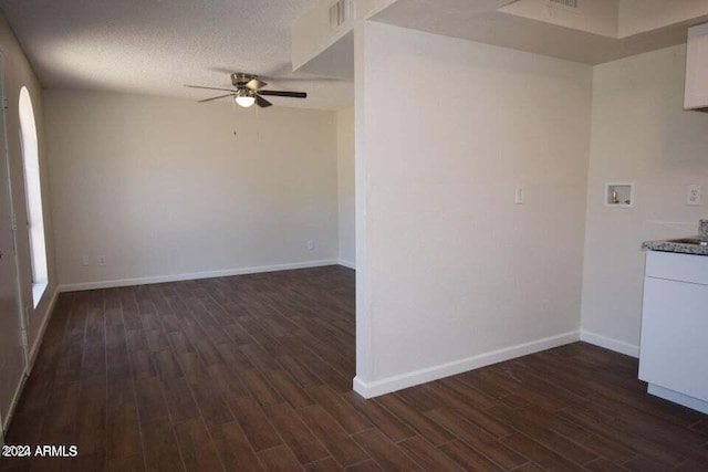 unfurnished room with ceiling fan, dark wood-type flooring, and a textured ceiling