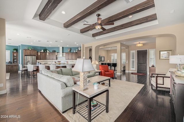 living room with hardwood / wood-style flooring, ceiling fan, and beam ceiling