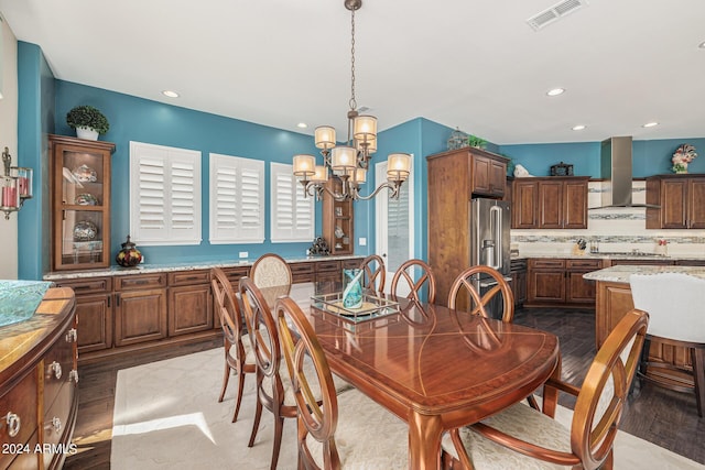 dining room with hardwood / wood-style flooring and an inviting chandelier