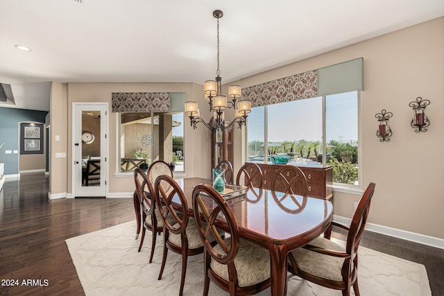 dining space with dark wood-type flooring and a chandelier