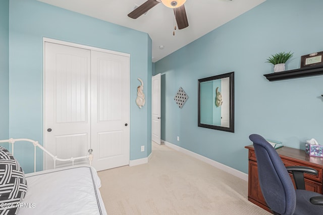 bedroom with light colored carpet, ceiling fan, and a closet