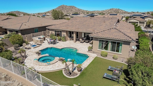 view of pool featuring an in ground hot tub, a mountain view, and a patio