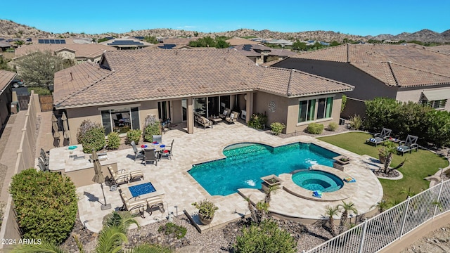 view of pool featuring a mountain view, a patio, and an in ground hot tub