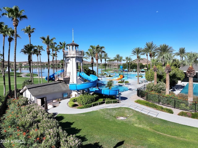 view of community with a water view, a yard, and a playground