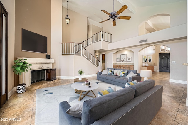 living room with beamed ceiling, high vaulted ceiling, and ceiling fan