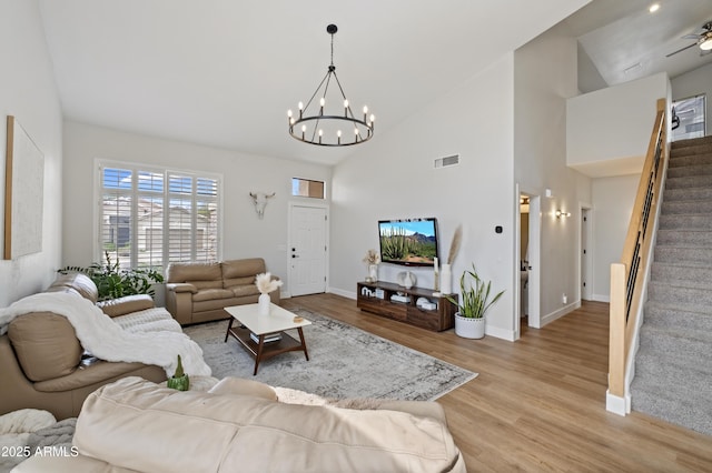 19203 N 39th Way, Phoenix, AZ 85050 - living area featuring visible vents, baseboards, light wood-type flooring, stairway, and ceiling fan with notable chandelier