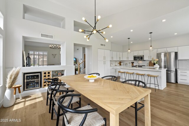 19203 N 39th Way, Phoenix, AZ 85050 - dining space with light wood-type flooring, an inviting chandelier, and visible vents