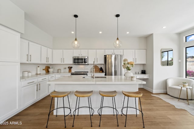 19203 N 39th Way, Phoenix, AZ 85050 - kitchen featuring a kitchen bar, white cabinets, a sink, stainless steel appliances, and decorative backsplash