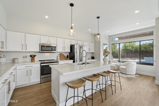 19203 N 39th Way, Phoenix, AZ 85050 - kitchen featuring light wood-type flooring, backsplash, white cabinets, appliances with stainless steel finishes, and a sink
