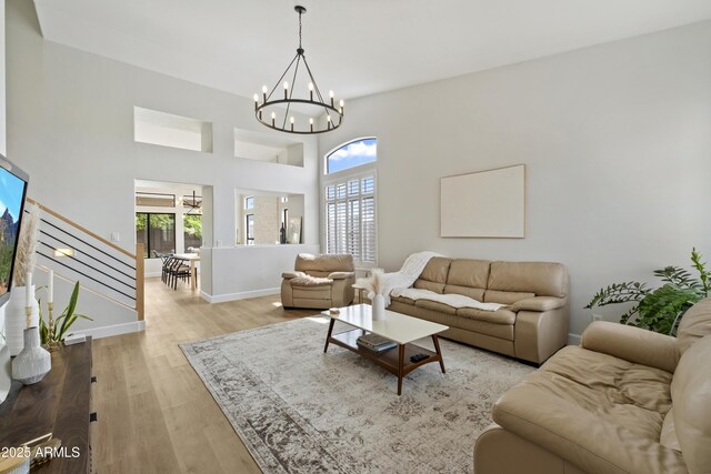 19203 N 39th Way, Phoenix, AZ 85050 - living area with a towering ceiling, a notable chandelier, baseboards, stairway, and light wood-style flooring