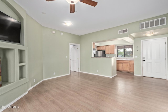 unfurnished living room featuring light wood-style floors, baseboards, and visible vents