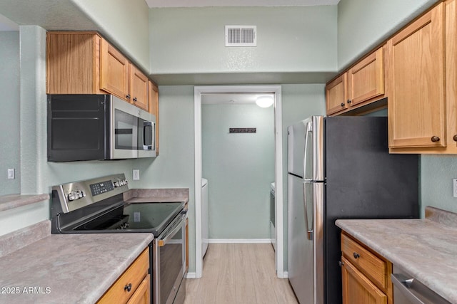 kitchen featuring visible vents, baseboards, appliances with stainless steel finishes, light countertops, and light wood-style floors