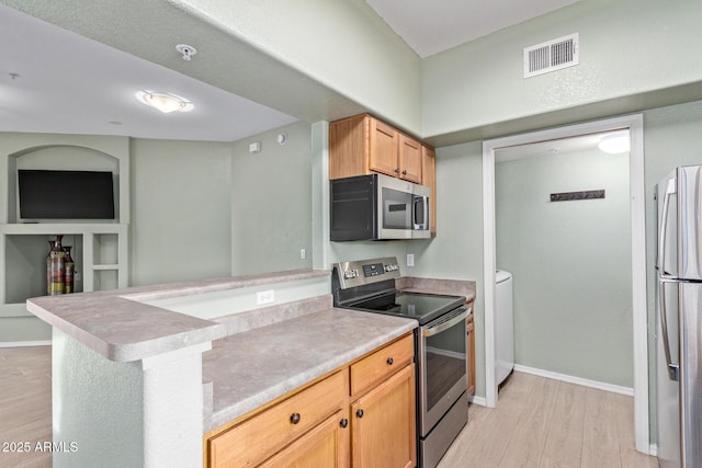 kitchen with stainless steel appliances, visible vents, baseboards, light countertops, and light wood finished floors