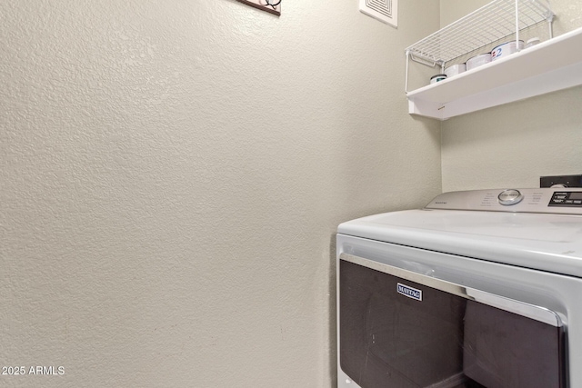 laundry room with washer / dryer, laundry area, visible vents, and a textured wall